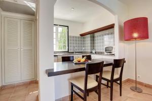 a kitchen with a table and chairs and a red lamp at Grupotel Club Menorca in Son Xoriguer