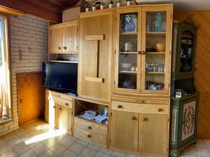 una cucina con armadi in legno e una TV di Résidence Le Sporting Cabourg a Cabourg