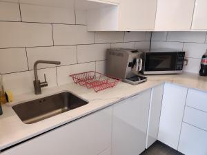 a kitchen counter with a sink and a microwave at 1 bed flat near Little Venice and Paddington in London