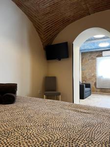a bedroom with a bed and a tv on the wall at Consolación17 in Cáceres