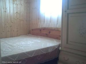 Cama pequeña en habitación con ventana en Rybacka chata, en Rusinowo