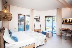 a bedroom with a bed and a desk and windows at Vistamare Suite & Room in Marina di Campo
