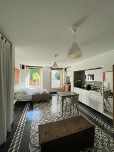 a large living room with a bed and a table at Le bonheur de la campagne à la ville - Grand studio en plein coeur de la ville in Nîmes