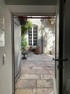 an open door to a courtyard with a patio at Le bonheur de la campagne à la ville - Grand studio en plein coeur de la ville in Nîmes