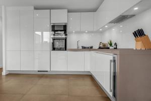 cocina con armarios blancos y encimera en Modern One Bedroom Apartments in Old Street en Londres