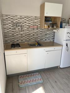 a kitchen with white cabinets and a white refrigerator at B&B Lucius in Pompei