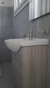 een badkamer met een witte wastafel en een spiegel bij Casa Athena in Crotone