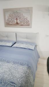 een slaapkamer met een bed met een boomafbeelding aan de muur bij Casa Athena in Crotone