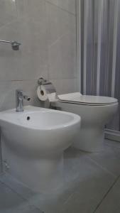 een witte badkamer met een toilet en een wastafel bij Casa Athena in Crotone