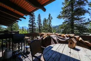 a wooden deck with a table and chairs and a bird house at Mammoth West #143 Condo in Mammoth Lakes
