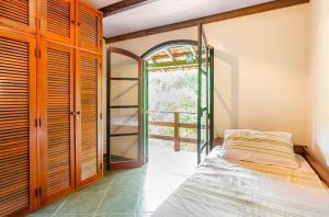 um quarto com uma cama e uma porta aberta em Sítio Borges em Petrópolis