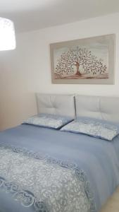 een slaapkamer met een bed met een boomafbeelding aan de muur bij Casa Athena in Crotone