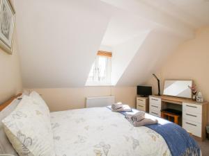 1 dormitorio con cama, escritorio y ventana en The Wynnstead Annexe, en West Felton