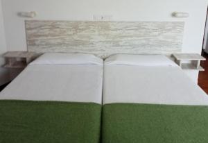 アーロにあるPortal De La Riojaの緑と白の部屋のベッド2台