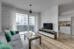 a living room with a couch and a tv at Bastion View TriApart in Gdańsk