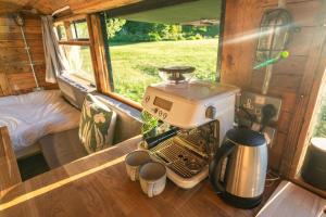 a coffee maker on a table in a tiny house at Delightful 2 Bed Double Decker Bus with Hot Tub in Uckfield