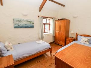 a bedroom with two beds and a window at The Barn at Harrolds Farm in Jeffreston