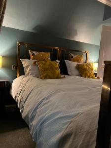 a bedroom with a large bed with yellow pillows at A charming, well appointed Edwardian Gate Lodge in Alyth