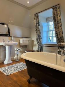 a bathroom with a bath tub and a sink at A charming, well appointed Edwardian Gate Lodge in Alyth