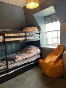 a room with three bunk beds and a window at A charming, well appointed Edwardian Gate Lodge in Alyth