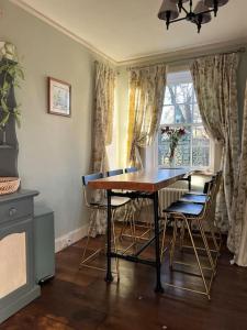 a dining room with a table and chairs and a window at A charming, well appointed Edwardian Gate Lodge in Alyth