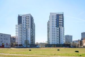 two tall buildings in a field in a city at Bastion View TriApart in Gdańsk