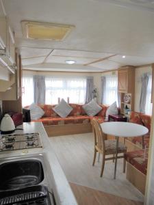 a kitchen and living room with a couch and a table at 6 Berth on Golden Sands (Westbrook Tahiti) in Ingoldmells