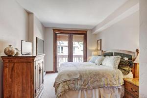 a bedroom with a bed and a dresser and a window at Mc308 Mill Club Condo in Copper Mountain