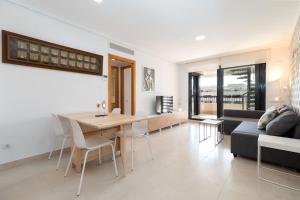 ein Wohnzimmer mit einem Tisch und einem Sofa in der Unterkunft ApartUP Patacona Sunrise Duplex in Valencia