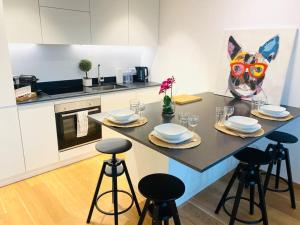 una cucina con tavolo, piatti e bicchieri di Luxury Brand New Flat with Terrace & Parking - RTL1 a Lussemburgo