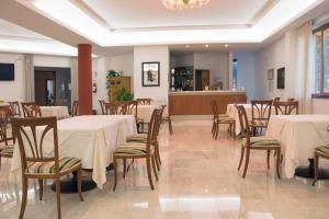 a dining room with tables and chairs and a bar at Ruggiero Park Hotel in Vallo della Lucania