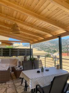 a table and chairs on a patio with a wooden roof at Seavota Comfort Apartment in Sivota