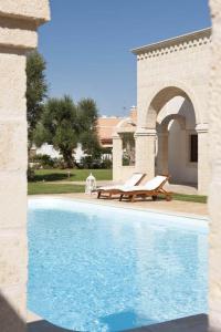 a swimming pool with a bench next to a house at Donna Lucrezia in Pezze di Greco