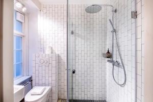 a white bathroom with a shower and a toilet at The Churchill 5 - Into This Place in Copenhagen