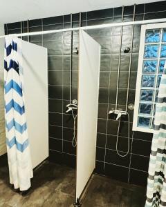 a bathroom with a shower with black tiles at Alojamiento Camino Portugues in Porriño