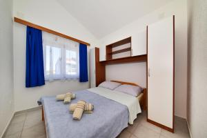 a bedroom with a bed with two towels on it at Apartment Ivo Kaurinovic in Zaton
