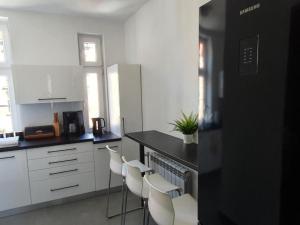 kuchnia z białymi szafkami i czarnym blatem w obiekcie GLIWICKA 16 w mieście Katowice
