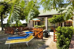 un patio con mesas y sillas y un edificio en Residence Mare Pineta, en Casal Borsetti