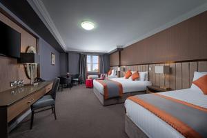 a hotel room with two beds and a desk at Midlands Park Hotel in Portlaoise