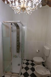 La salle de bains est pourvue de toilettes et d'un lustre. dans l'établissement a casa di Ale, à Lucques