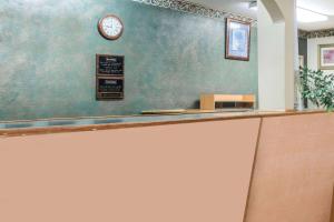 a cashier counter with a clock on a wall at Travelodge by Wyndham Temple in Temple