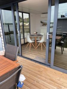 a patio with a table and chairs on a balcony at Hausboot Claudia Schleswig in Schleswig