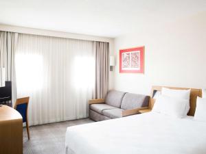 a hotel room with a bed and a couch at Novotel Gent Centrum in Ghent