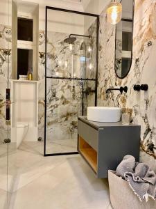 a bathroom with a sink and a shower and a toilet at AK Apartments in Warsaw