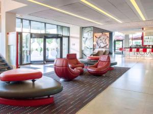 a lobby with chairs and tables in a store at Novotel Sofia in Sofia