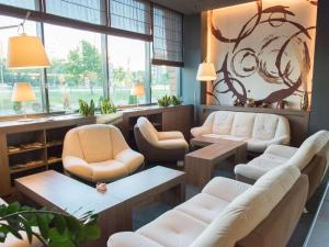 una sala d'attesa con sedie e tavoli bianchi di Novotel Sofia a Sofia