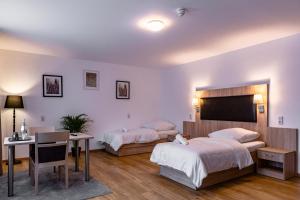 Habitación de hotel con 2 camas y escritorio en Motel Zur Dachsbaude, en Wandlitz