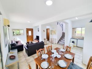 a dining room and living room with a table and chairs at Sunnyside Pool Villa in Ayia Napa