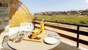a table with a plate of food and a bottle of wine at Aether Green Apartments in Nea Roda +17 photos