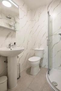 a white bathroom with a sink and a toilet at Spacious En-suite Private Double Bedroom in Oxford